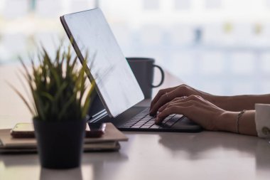 Bulanık fotoğraf, dizüstü bilgisayar ve belge ofis masasının penceresine konuldu. Enerji tasarrufu yapmak için doğal ışığı gün boyunca çalışmak ve iş adamlarını mutlu etmek ve iş konuşmak için kullanıyor..