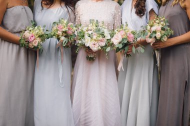 Açık havada duran buketleri elinde nedime gelinle