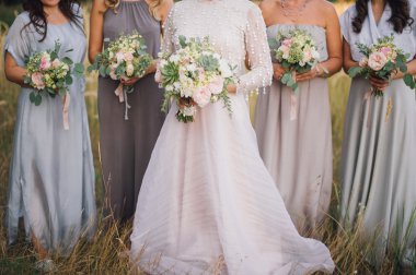 Açık havada duran buketleri elinde nedime gelinle