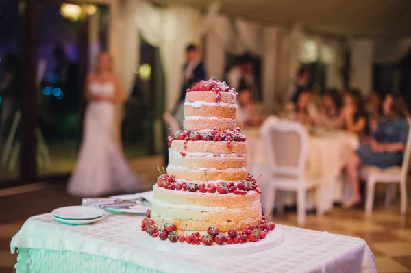Multi level white wedding cake with fresh ripe berries