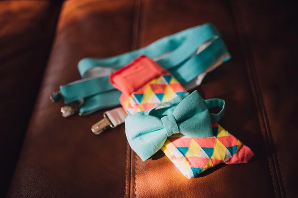 Close up view of colorful men\'s accessories: suspenders, bow tie and socks