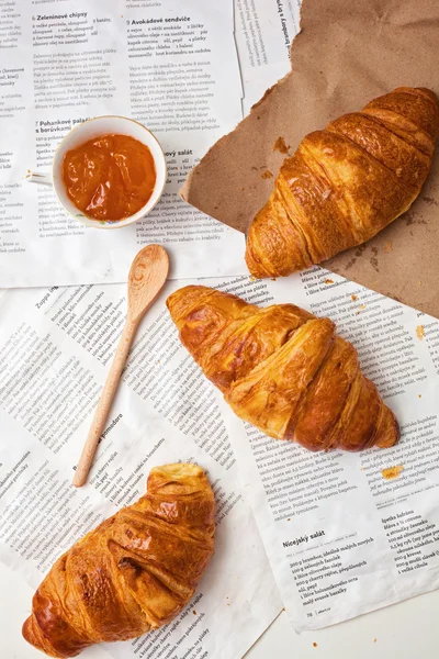 Croissant su uno sfondo dei giornali con marmellata — Foto Stock