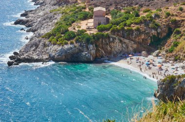 İtalya 'daki cennet plajı: mükemmel şeffaf turkuaz su, yeşil taşlarla çevrili beyaz çakıllar. 