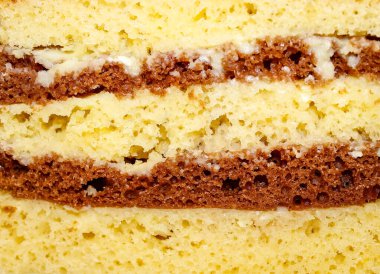 Kremaya batırılmış, iki renkli bisküvilerden yapılmış bir kekin yakın plan kesimi. Makro, seçici çekim..