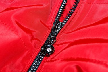 Kırmızı ceketin üzerine koyu renk fermuar kilidi. Seçici atış.