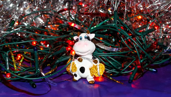 輝くガーランドとチンセルの間の雄牛の図 新年のシンボル2021年 お祝いのクリスマスカード 選択的ショット — ストック写真