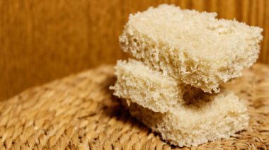 Ahşap arka planda taze gri ekmek dilimleri. Yakın çekim, seçici çekim.