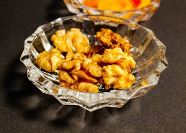 Siyah arka planda ceviz olan kristal kase. Seçici atış.