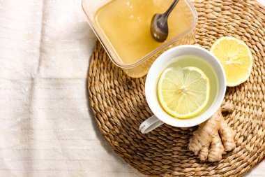 Limon ve ballı sıcak içecek. Yanında zencefil ve limon var. Grip ve soğuk algınlığı önleme ve tedavi kavramı. Kapat..