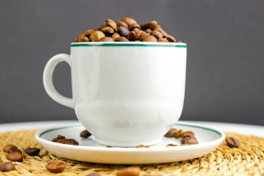 Beyaz bardakta kavrulmuş kahve çekirdekleri. seçici çekim.