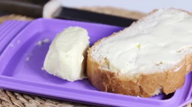 Tereyağlı bir parça beyaz ekmek kes. Kahvaltıda sandviç. Yakın plan..