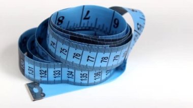 Beyaz arka planda ölçmek için mavi santimlik bant. Döner masa. Yakın plan.