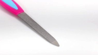 Beyaz arka planda manikür tırnak törpüsü. Döner masa. Seçici atış.