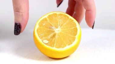 Bir kadının eli masadan yarım limonu alır ve geri koyar. Yakın plan..