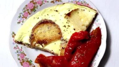 Kahvaltıda ekmek ve yanında dolmalık biberli omlet. Döner masa. Seçici odak.
