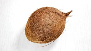 Beyaz ahşap arka planda bir hindistan cevizi. Yukarıdan görünüşü.