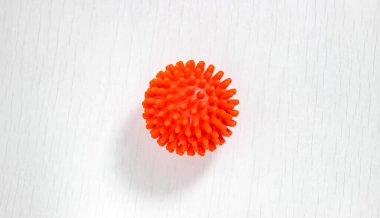 Koronavirüs molekülünü sembolize eden kırmızı bir masaj topu. Yakın çekim, üst görünüm.
