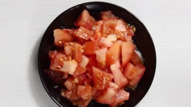 Olgun domatesleri ince ince doğranmış bir tabağa koy. Yukarıdan görünüşü.