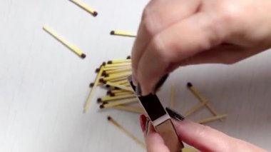 Chelyabinsk, Rusya - 19 Ocak 2021: Bir kadının eli bir kutuya karşı kibrit çakıyor. Yakın çekim, seçici çekim