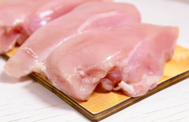 Çiğ tavuk filetosu doğrama tahtasının üzerinde. Seçici atış.