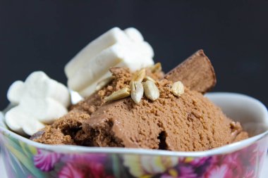 Çukulatalı dondurma, marşmelov, tohum ve çikolata parçacıklarıyla süslenmiş. Yakın plan..