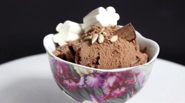 Çukulatalı dondurma, marşmelov, tohum ve çikolata parçacıklarıyla süslenmiş. Yakın plan..