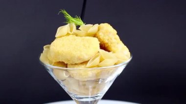 İçinde nugget ve makarna bulunan bir cam kokteyl bardağı ve pipet. Yaratıcı natürmort. Yakın plan..