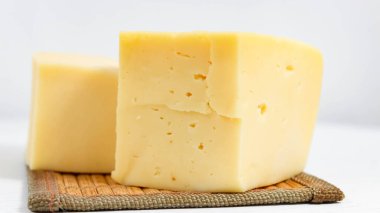 Hafif bir arka planda sert peynirin yakın plan görüntüsü. Seçici atış.