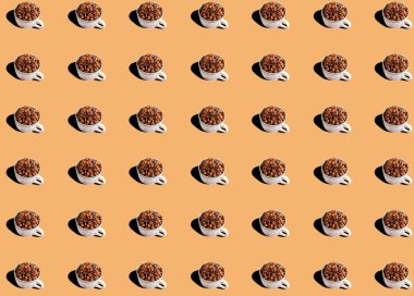 Bej arka planda beyaz bardakta kavrulmuş kahve çekirdekleri. Sanatsal tasarım. Market baskıları. Şablon.