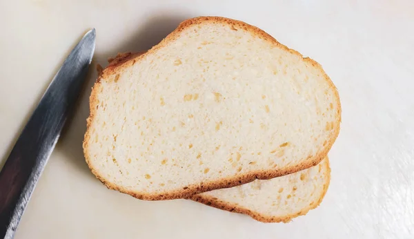 Два Шматки Білого Хліба Світлій Поверхні Ножем Лежить Поруч Вид — стокове фото