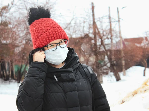 Ένα Κορίτσι Χειμερινό Καπέλο Βάζει Μια Προστατευτική Μάσκα Στο Πρόσωπό — Φωτογραφία Αρχείου