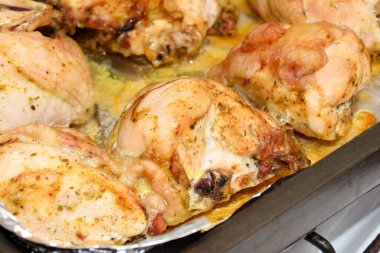 Kavrulmuş tavuk butları yakın plan bir yemek tepsisinde. Seçici atış.