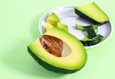 Soyulmuş, dilimlenmiş avokado tabakta farklı parçalar halinde duruyor. Diyet yemeği. Seçici atış.