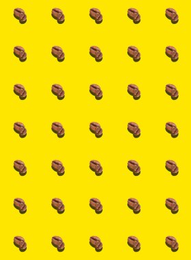 A pattern of roasted coffee beans on a yellow background. Coffee pattern. Templates, prints.