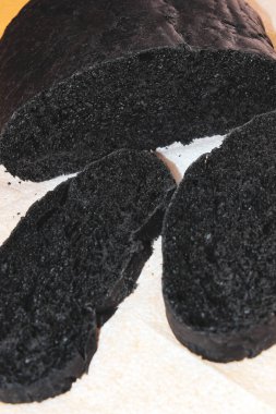 Aktif karbonla dilimlenmiş sağlıklı siyah ekmek. Dikey çerçeve, seçici çekim.