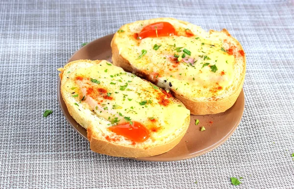 İki lezzetli sandviç, erimiş peynir ve çay tabağında otlar. Bir şeyler atıştır. Yakın çekim, seçici çekim.