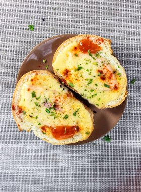 Sandwiches with melted cheese and spices on a plate. Top view.
