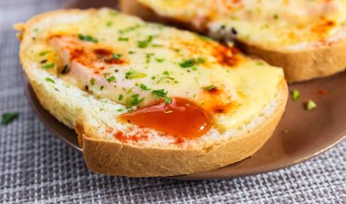 İki lezzetli sandviç, erimiş peynir ve çay tabağında otlar. Bir şeyler atıştır. Yakın çekim, seçici çekim.