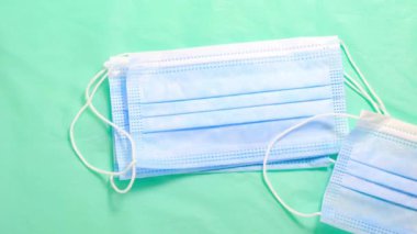 Hareket animasyonunu durdur. Eldivenli elleri teker teker götüren tıbbi koruyucu maskeler. Üst görünüm.