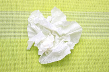 Yeşil arka planda buruşmuş kağıt peçete. Üst görünüm, seçici çekim.