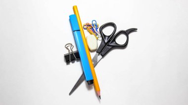 Farklı ofis kırtasiyeleri beyaz yüzeyde hareket eder. Üst görünüm.