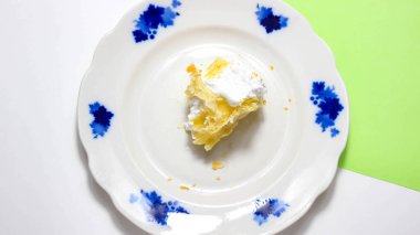 Tabağında protein kremi olan yarısı yenmiş bir brownie. Üst görünüm, seçici çekim.