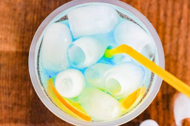 Kamışlı ve buzlu bardakta ferahlatıcı bir kokteyl. Üst görünüm.