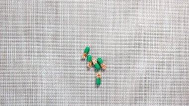 Hareket animasyonunu durdur. Kapsüllerdeki, tabletlerdeki veya vitaminlerdeki ilaçlar masadan ele taşınıyor. Üst görünüm.