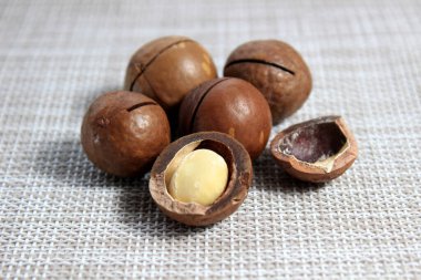 Tam ve soyulmuş macadamia fındıkları yakından. Seçici atış.