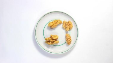 Hareket animasyonunu durdur. Ceviz çekirdekleri bir fincan tabağında hareket eder. Üst görünüm.