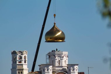 Chelyabinsk, Rusya-08.06.2021: İnşaat sırasında kilisenin altın kubbesini kaldıran bir vinç. Seçici atış.