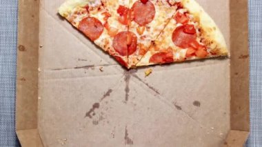 Hareket animasyonunu durdur. Pakette baharatlı pizza, parçalara ayrılmış. Üst görünüm.