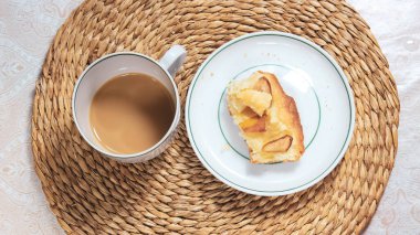 Kupada süt ve yarısı yenmiş Charlotte 'un yarım kalmış kahvesi. Üst görünüm, seçici çekim.