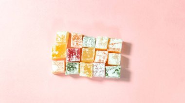 Pembe arka planda renkli Türk lokumu. Üst görünüm.